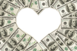 One hundred dollar bills in the shape of a heart isolated on white background The love of money