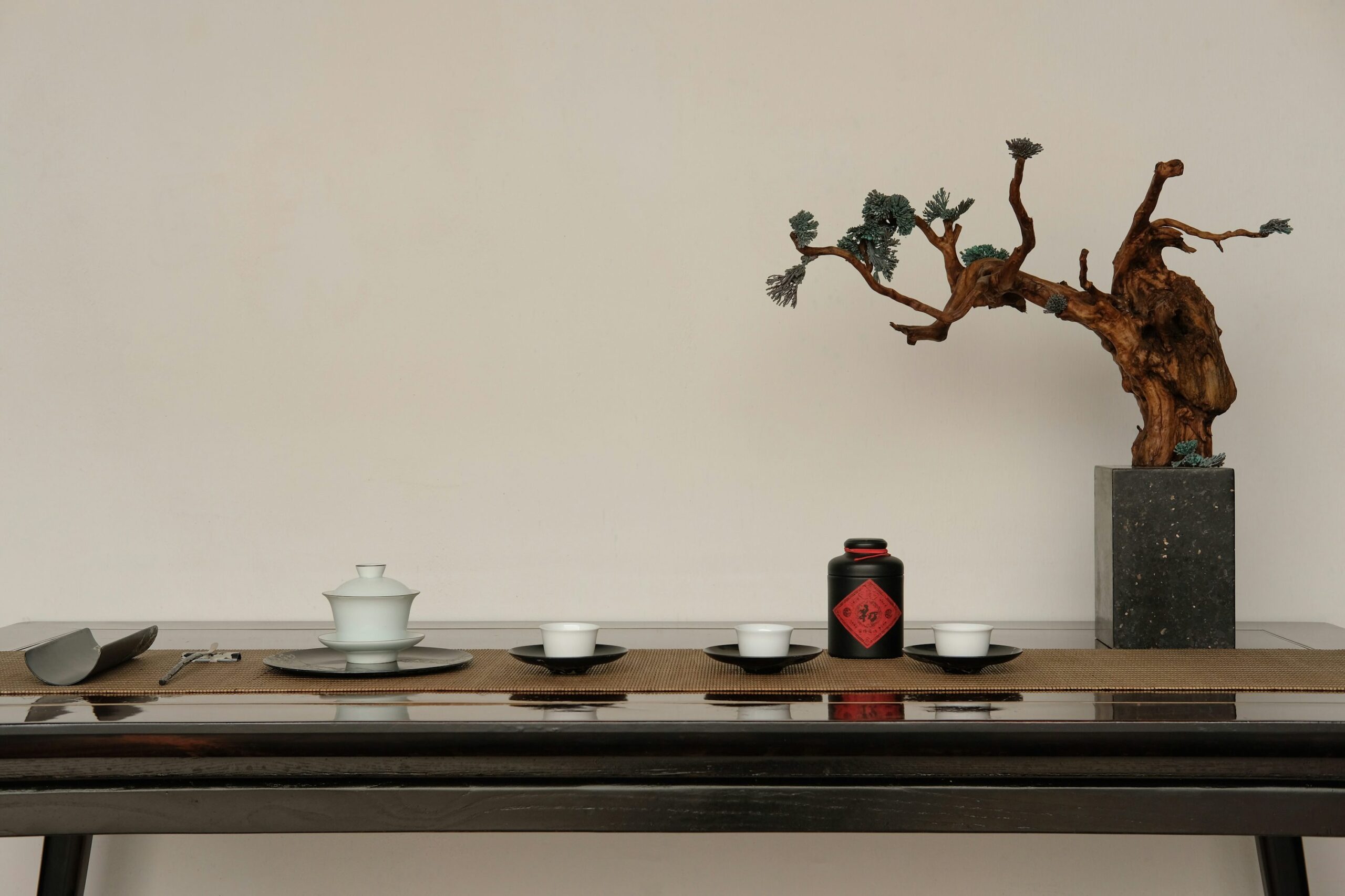 A minimalist depiction a gaiwan tea set: a brewing vessel with a lid, and three small cups and saucers.