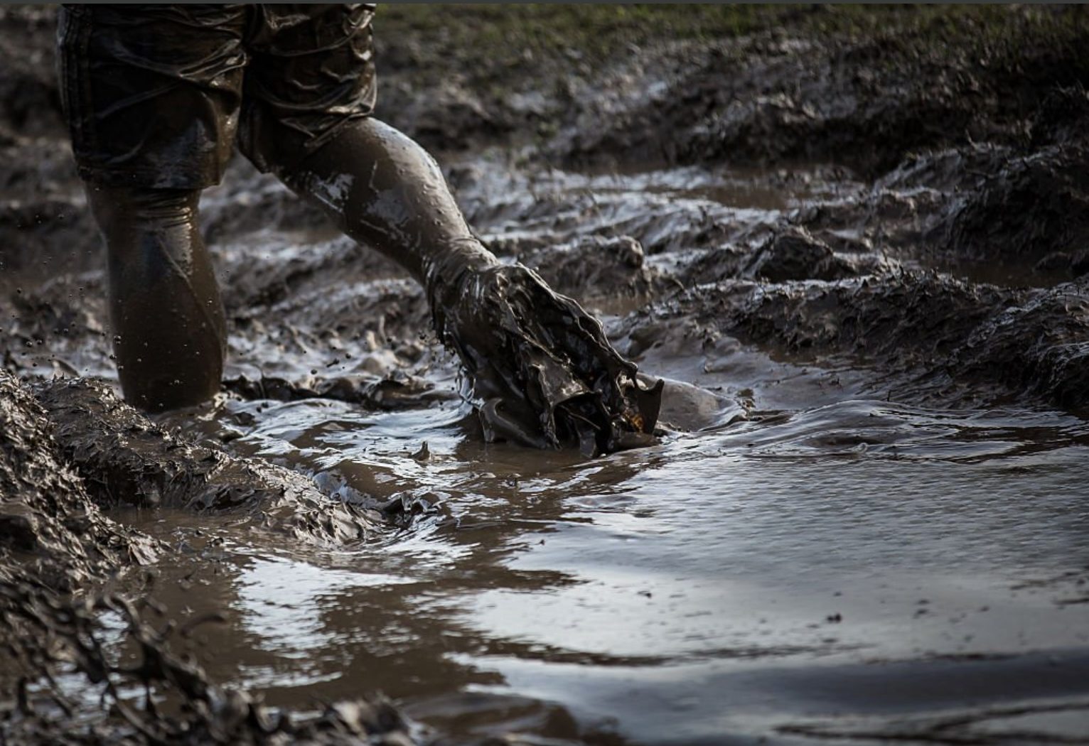 Person trudging through deep mud, representing the slow and costly grind of misplacing SEO priorities.